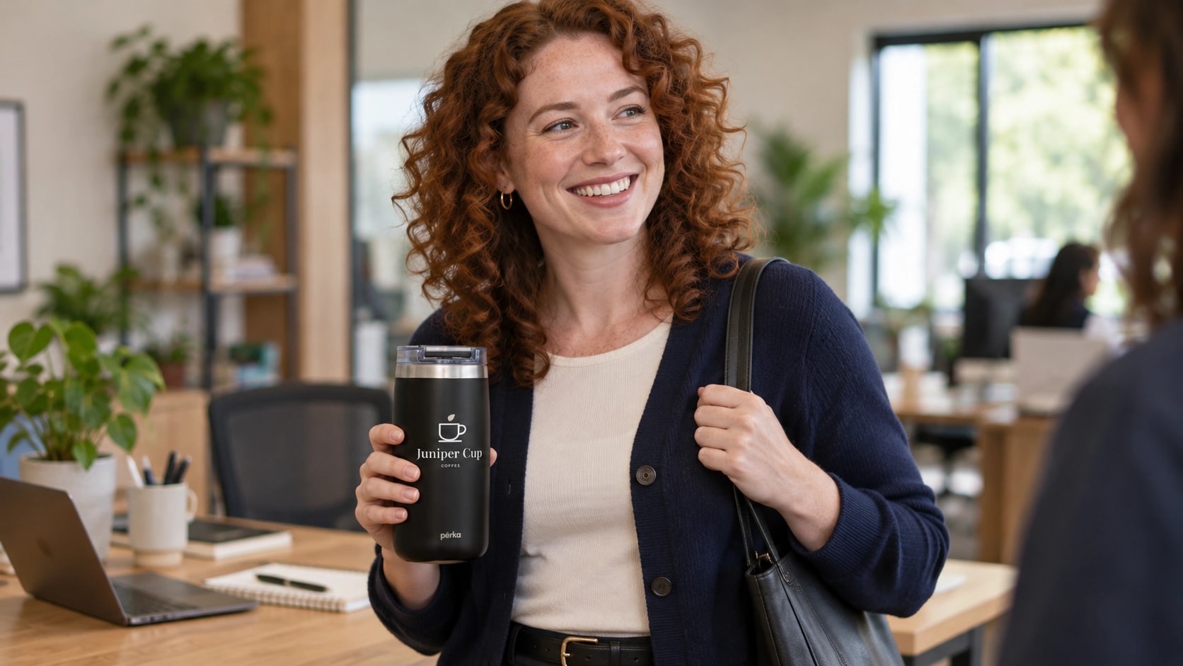 Illustrative scene of a woman taking a Perka travel tumbler with sample Juniper Cup branding along from her office