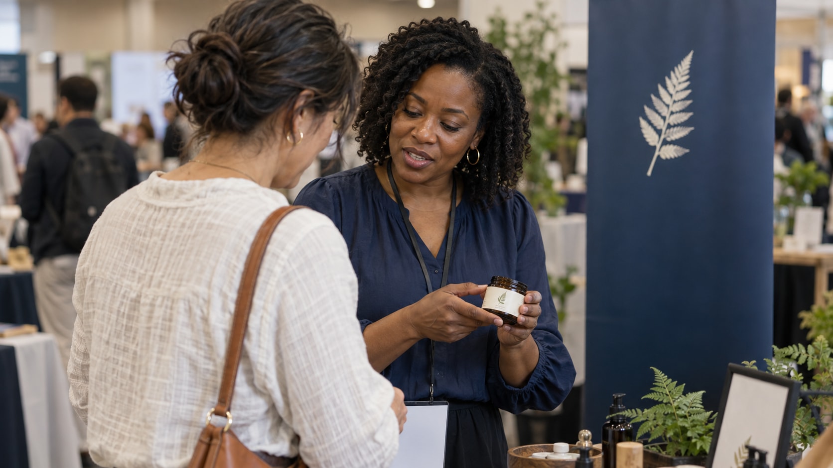 Cinematic artwork of an exhibitor showing a product to a visitor at a trade show booth